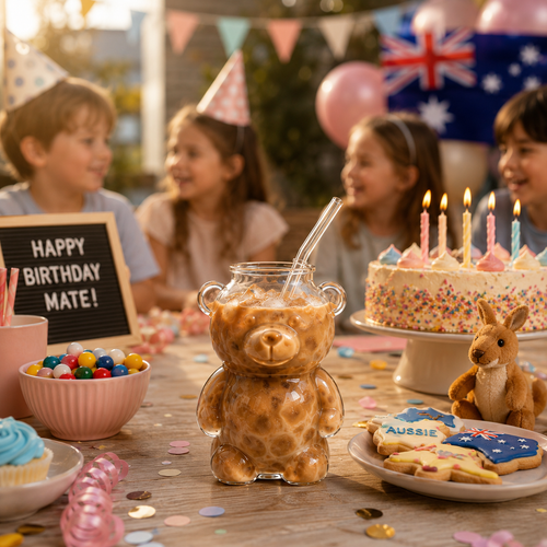 Bear glass cup with glass straw on a birthday party table with desserts