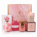 Full contents of the pamper hamper on white background with pink marble box, bath bomb, diamond soap, jar of bath salt grains, lit soy candle and 3D carnation greeting card